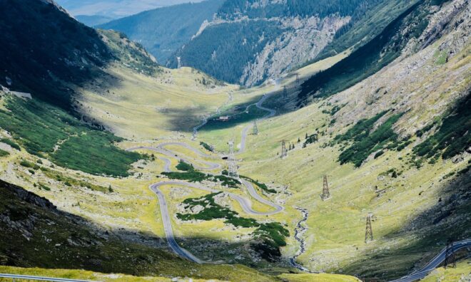 Șoseaua Transfăgărășan serpuind printr-o vale de munte din Carpații românești