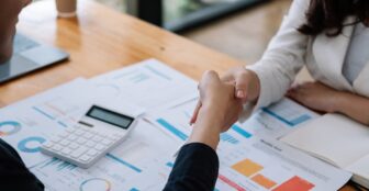 Calculator și contract așezate pe birou pentru compararea ofertelor