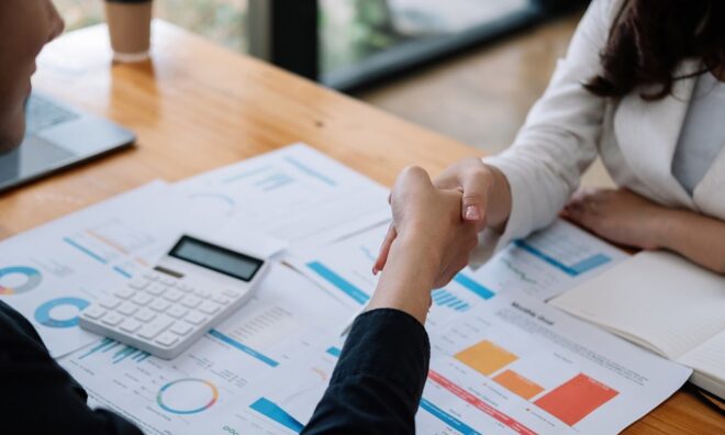 Calculator și contract așezate pe birou pentru compararea ofertelor
